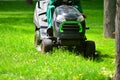 Professional lawn mower grass cutting in a park.