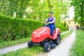 Professional lawn mower worker cutting grass in home garden Royalty Free Stock Photo