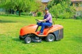 Professional lawn mower worker cutting grass in home garden Royalty Free Stock Photo