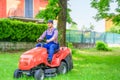 Professional lawn mower worker cutting grass in home garden Royalty Free Stock Photo