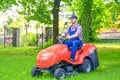 One gardener driving riding lawn mower garden Royalty Free Stock Photo