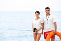 Professional lifeguards with life buoy and binocular at beach