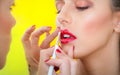 Professional lips make-up. Makeup professional artist applying lip gloss Royalty Free Stock Photo