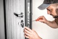 Locksmith repairing home entrance door lock Royalty Free Stock Photo