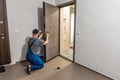 Professional locksmith repairing installing home entrance door lock Royalty Free Stock Photo
