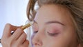 Professional make-up artist applying cream base eyeshadow primer to model eye Royalty Free Stock Photo