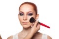 Professional Make-up artist doing glamour with red hair model makeup. Isolated background. Royalty Free Stock Photo