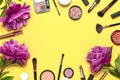 Professional makeup brushes, powder, eyeshadow, blush, lipstick cream on yellow background flat lay top view copy space. Beauty Royalty Free Stock Photo