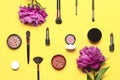 Professional makeup brushes, powder, eyeshadow, blush, lipstick cream on yellow background flat lay top view copy space. Beauty Royalty Free Stock Photo