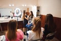 Professional makeup teacher training her student girl to become makeup artist. Makeup tutorial lesson at beauty school