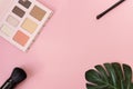 Professional makeup tools palette of multicolor cosmetic make up set with brushes and a monstera leaf on pink background. Beauty Royalty Free Stock Photo