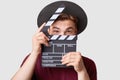 Professional male actor ready for shooting film, holds movie clapper, prepares for new scene, wears special clothes, isolated on w Royalty Free Stock Photo