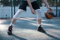 Professional male american basketball player in action with ball dribbling on court outdoors, close up cropped photo Royalty Free Stock Photo