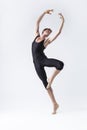 Professional Male Ballet Dancer Man in Black Dance Suit Tights Posing in Lifted Ballanced Dance Pose With Hands Circled in Studio