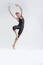 Professional Male Ballet Dancer Young Man in Black Dance Tights Suit Posing in Ballanced Dance Pose With Lifted Hands in Studio