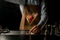 Professional male bartender throwing a red rose bud to a martini glass with a cocktail Royalty Free Stock Photo