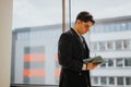 Focused business associate reviewing documents outdoors with city background