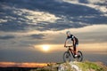 Energetic man in sportswear cycling on rock hill. Royalty Free Stock Photo