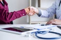 Professional Male doctor in white coat shaking hand with female Royalty Free Stock Photo