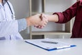 Professional Male doctor in white coat shaking hand with female Royalty Free Stock Photo