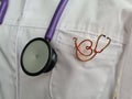 Professional male general practitioner or cardiologist in white uniform with stethoscope sign