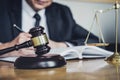 Professional Male lawyer or judge working with contract papers, documents and gavel and Scales of justice on table in courtroom, Royalty Free Stock Photo