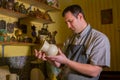 Professional male potter examining jug in pottery workshop Royalty Free Stock Photo