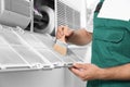 Professional male technician cleaning air conditioner, closeup. Repair and maintenance Royalty Free Stock Photo