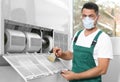 Professional male technician cleaning air conditioner. Repair and maintenance Royalty Free Stock Photo