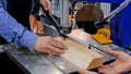 Carpenter using bandsaw tool, cutting piece of wood at workshop - close up Royalty Free Stock Photo