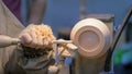 Carpenter using chisel for shaping piece of wood on lathe - close up view