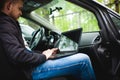 Professional man with a laptop in car tunes tuning control system Royalty Free Stock Photo