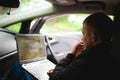 Professional man with a laptop in car tunes tuning control system, updating software, gaining access through to computer Royalty Free Stock Photo