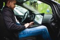 Professional man with a laptop in car tunes tuning control system, updating software, gaining access through to computer Royalty Free Stock Photo