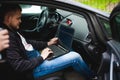 Professional man with a laptop in car tunes tuning control system, updating software, gaining access through to computer Royalty Free Stock Photo