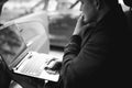 Professional man with a laptop in car tunes tuning control system, updating software, gaining access through to computer Royalty Free Stock Photo