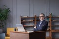 Professional man sitting in office in front of laptop. Developer thinking on solutions for work. Home-based worker on desktop Royalty Free Stock Photo