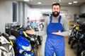 professional man worker displaying various motorcycles in workshop Royalty Free Stock Photo