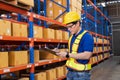 Professional Man Worker wearing hard hat checks stock and inventory with Clipboard in the retail of shelves with goods Royalty Free Stock Photo