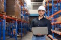 Professional Man Worker wearing hard hat checks stock and inventory with Laptop Computer. Looking at camera Royalty Free Stock Photo