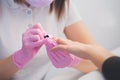 Professional manicure process in beauty salon. Closeup manicurist applies nail polish