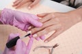 Professional manicurist showing colorful nail polish to check the finish result