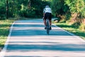 Professional marathon cyclist wearing all of his safety gear rides his bike in the green nature