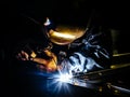 Professional mask protected welder man working on metal welding and sparks metal