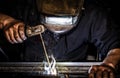 Professional mask protected welder man working on metal welding and sparks metal