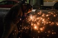 Professional mask protected welder man working on metal welding and sparks of metal at night. Employee welding steel with sparks Royalty Free Stock Photo