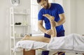 Professional masseur, physiotherapist, chiropractor or osteopath massaging woman& x27;s legs