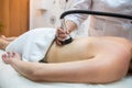 professional masseuse performs a cellulite treatment on the whole body with a special device.