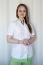 Professional masseuse in spa uniform on white background