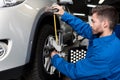 Professional mechanic adjusting automobile wheel alignment